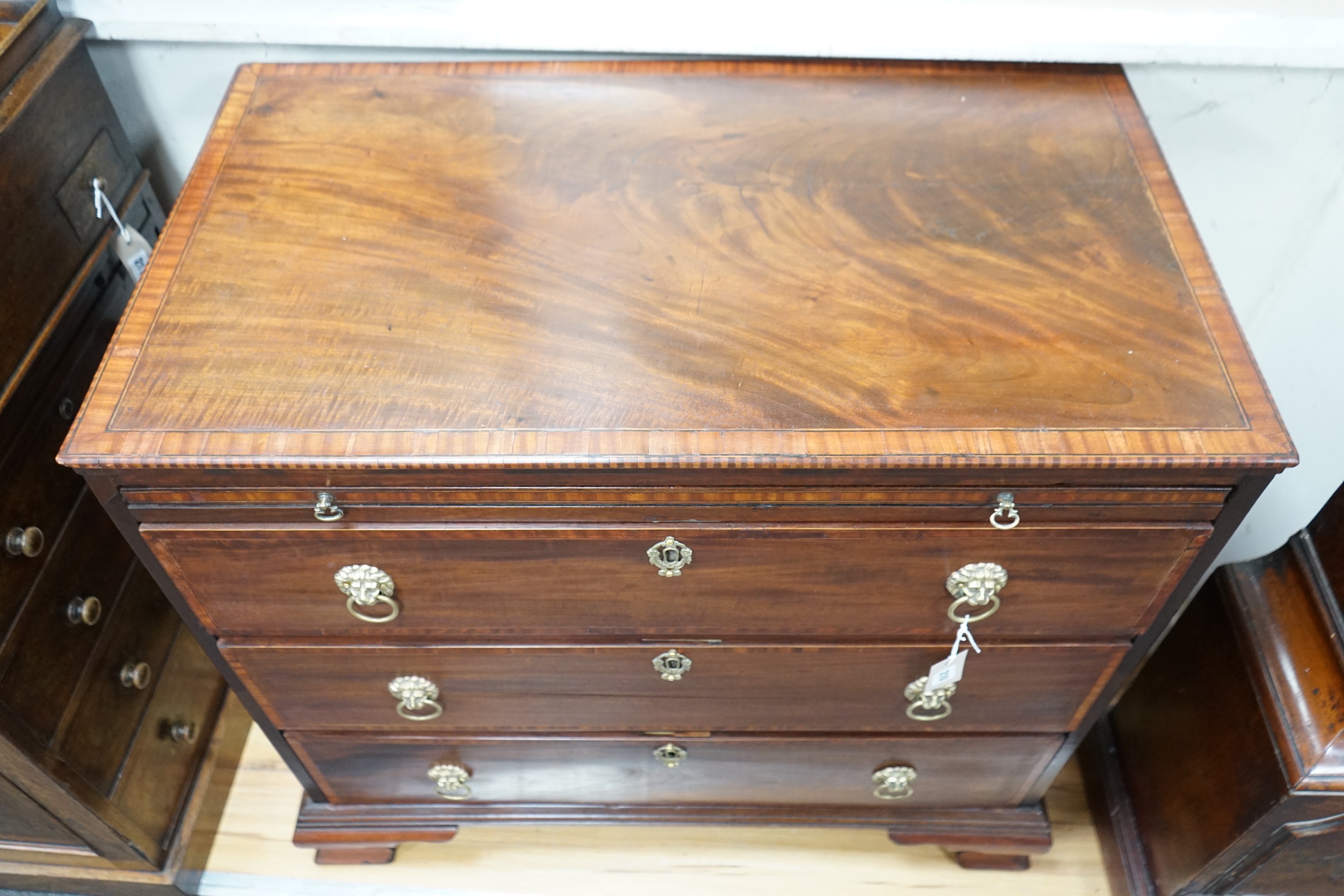 A George III and later banded mahogany chest of three drawers with brushing slide, width 85cm, depth 49cm, height 81cm *Please note the sale commences at 9am.